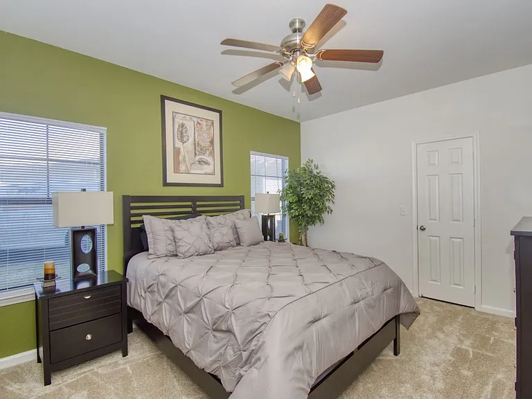 Comfortable bedroom with ceiling fan and natural light