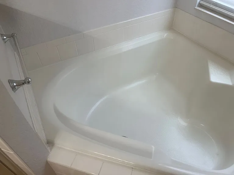 63 - Corner bathtub with ceramic tile surround.