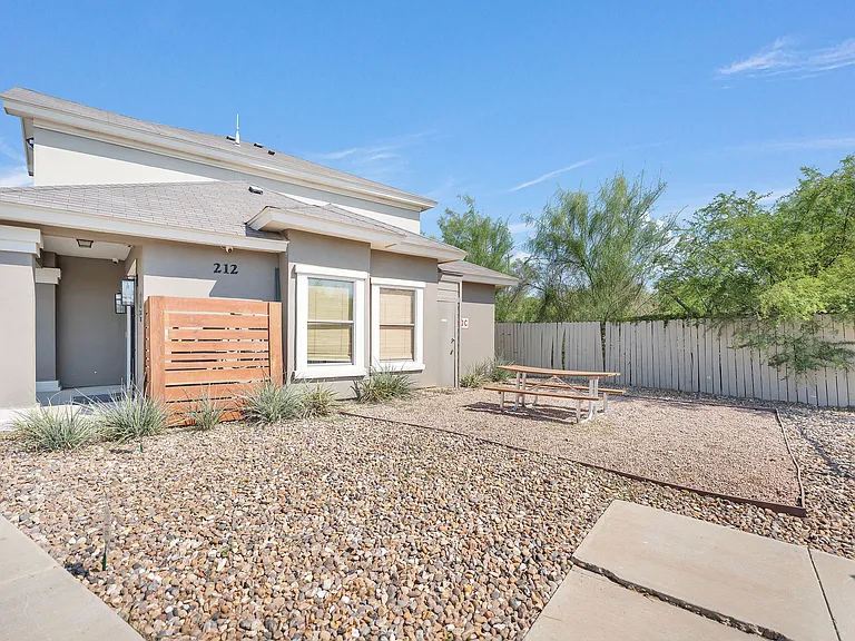 A home at La Joya Apartments in Laredo, Texas, featuring a picnic table and a gravel driveway