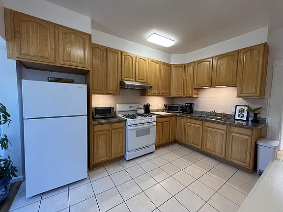 Kitchen with fridge, stove, oven, microwave and toaster oven. No dishwasher or garbage disposal.