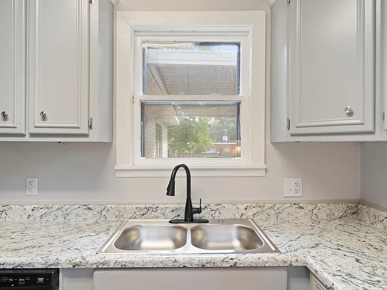 sink window overlooks fenced yard