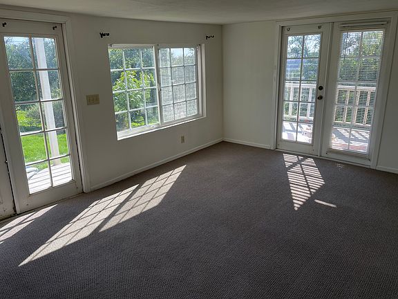 Living room. New carpet. Double French doors as entry (on left of photo) and to deck (on right)