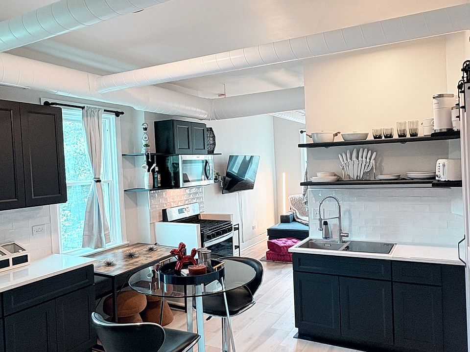 Fully furnished, open-concept kitchen and dining area with modern finishes and flexible seating