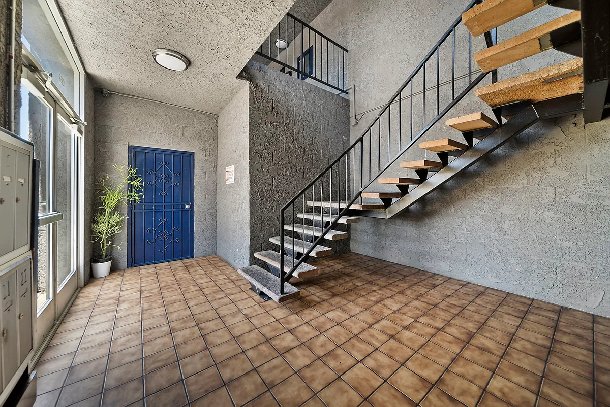 Clean interior corridor with convenient stair access to upper-level units. - Cedar Apartments