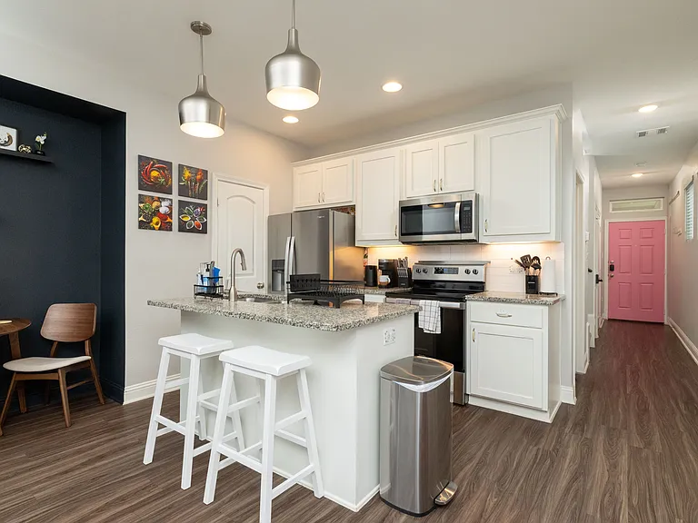 View of the fully stocked kitchen and hallway to the front door.