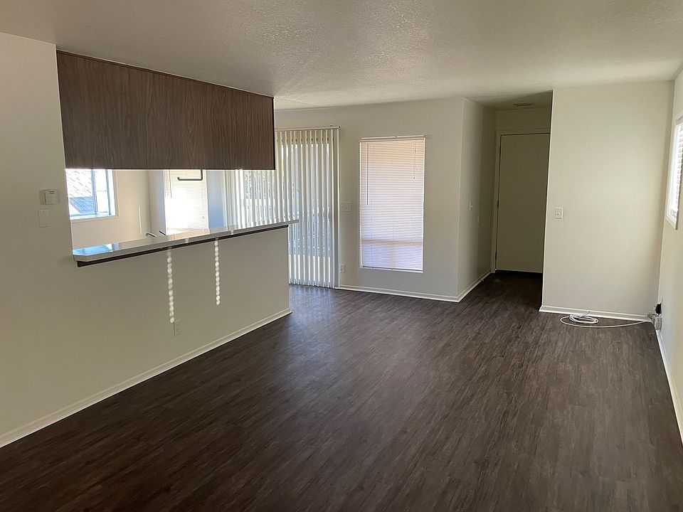 Living Room facing the front entry, Patio 1 and kitchen