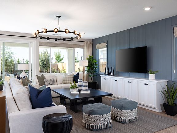 A cozy and modern living room with a large sofa, a coffee table, and a TV mounted on the wall, surro