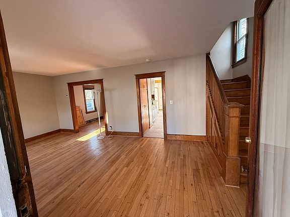 View through the front door entrance. Could be used as a living room area. Open hallway shows dining room (left) and kitchen (right)