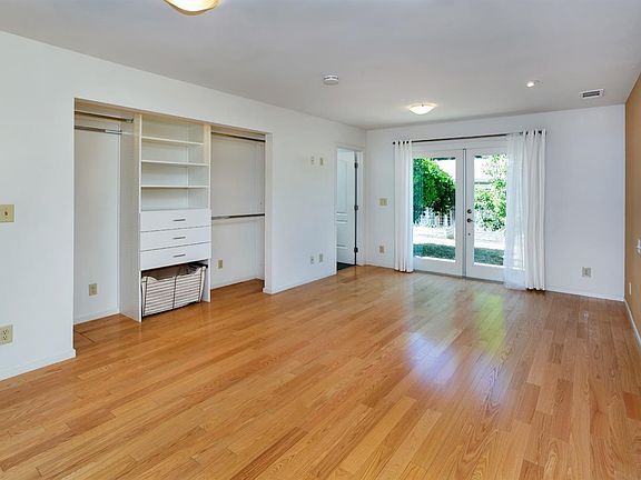 The primary bedroom with french doors leading to the private backyard