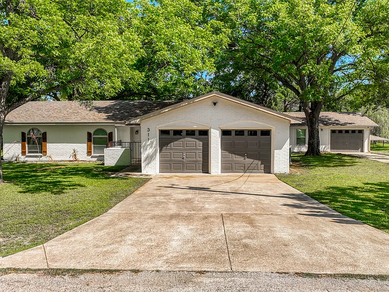 Front of house with double car garage and detached garage. Plenty of room to bring your boat!