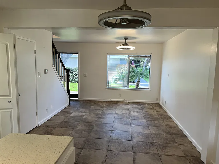 ground floor has stone like tile, 2 ceiling fan/light fixtures, window overlooking green belt, screen door on entry and door to private patio. 1/2 bath and laundry closet on the main floor as well.