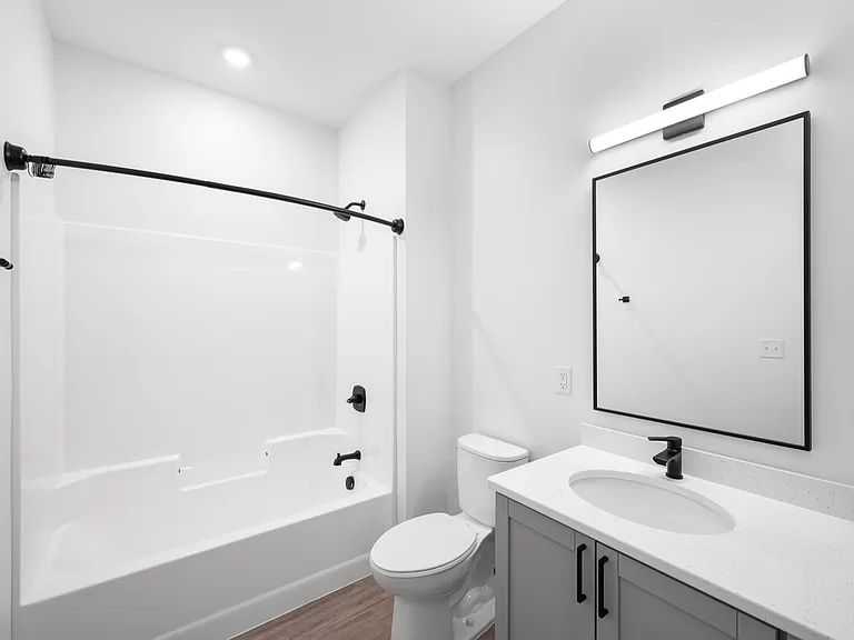 Modern apartment bathroom with elegant white fixtures, sleek vanity, and stylish lighting. Modern apartment bathroom with elegant white fixtures, sleek vanity, and stylish lighting.