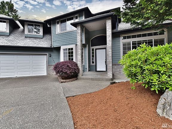 Cement planking with brick accents, 2-car garage and beautifully landscaped.