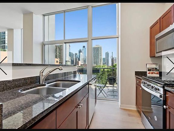 Kitchen looking East. Stainless steel appliances. Granite counters. Stainless steel sink.