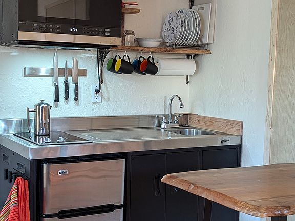 A very efficient kitchenette with a 2-burner cooktop, microwave, sink and mini-fridge. Necessary utensils and cookware included.