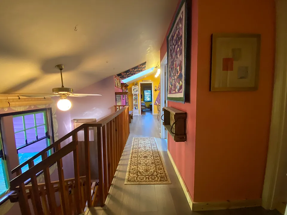 Walkway from primary to secondary bedroom with bathroom and kitchenette in between