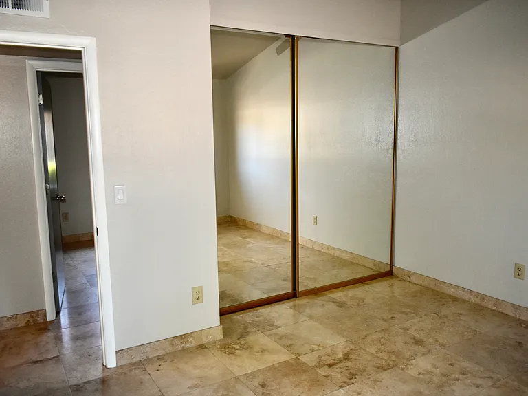 Master Bedroom closet has built-in shelves and rods and mirrored doors