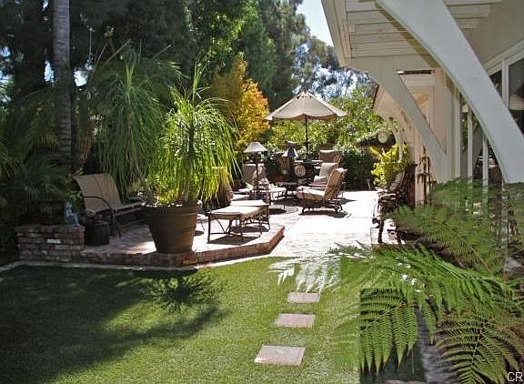 Idyllic backyard with turf lawn, brick hardscape accents, two-le