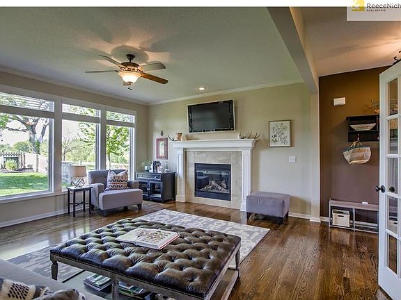 Large windows overlook the fenced backyard.