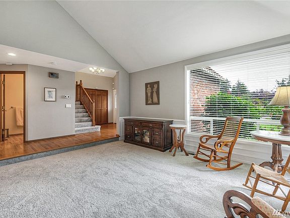 Another view of the living room looking toward the foyer and open rail staircase.