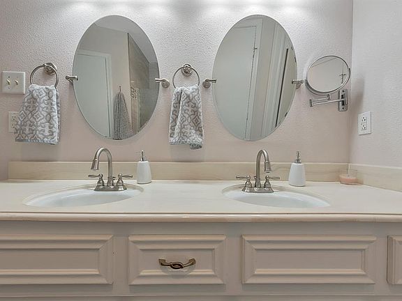 Updated Master Bath has adjustable mirrors, double sinks, stylish bath hardware.