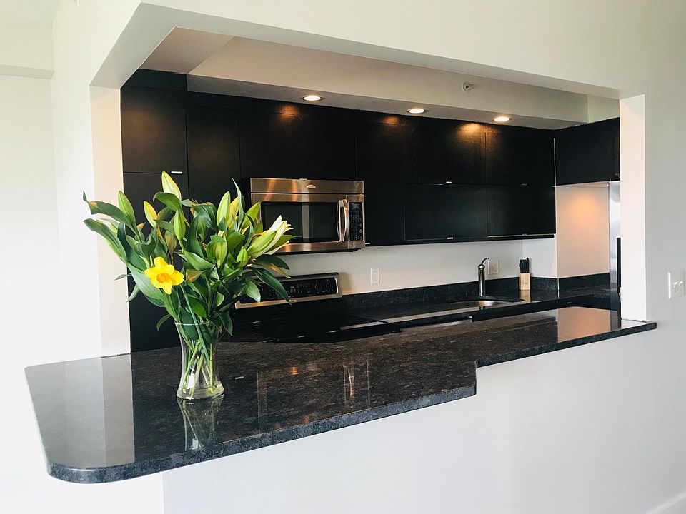 Kitchen with bar open to dining area, living room, and view of Casco Bay.