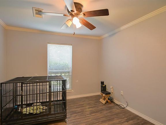 This extra room near the living area features dark stained ceiling fan, wood floors, and large window with privacy blinds!