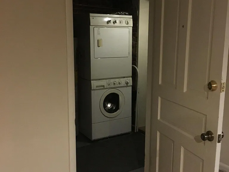View from bedroom into laundry/ boiler room. The stacked Meile washer and dryer are in view.