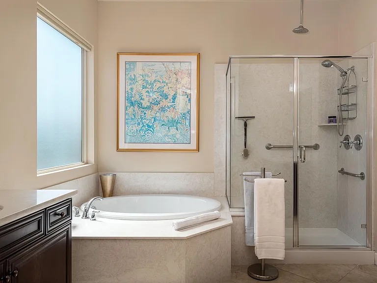 Spacious & well lit master bathroom view toward walk-in shower & jetted tub.
