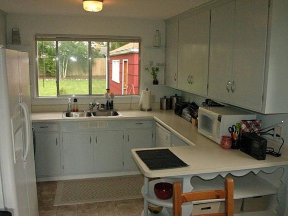 Spacious kitchen with fresh paint, newer counters, newer sink overlooking the backyard, new vinyl fl
