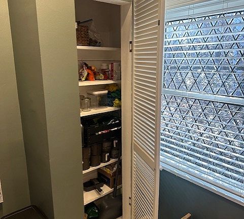 Eating area in kitchen was tall pantry and beautiful diamond, leaded windows facing nature