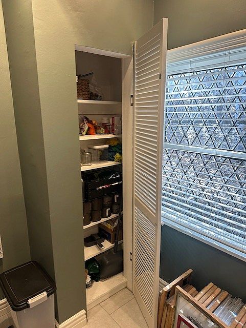 Eating area in kitchen was tall pantry and beautiful diamond, leaded windows facing nature