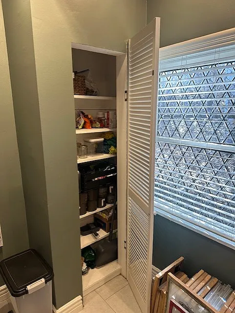 Eating area in kitchen was tall pantry and beautiful diamond, leaded windows facing nature