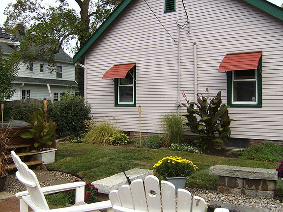 backyard with custom landscaping, hot tub, Fire pit and paver patio.
