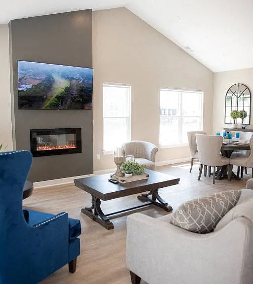 Interior of Champion Reserve Townhomes great room with cathedral ceiling, fireplace, and faux wood flooring.