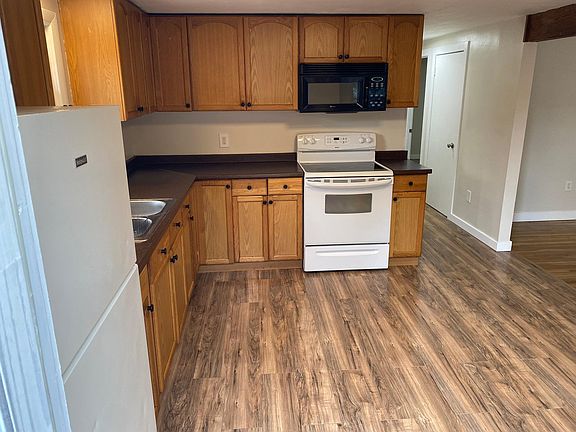 From front door looking into kitchen/down hallway, door visible goes to basement.