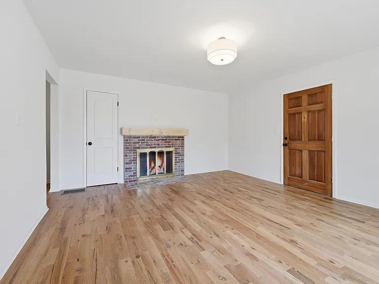 Gas fireplace, bright and sunny living room with large, east-facing picture window