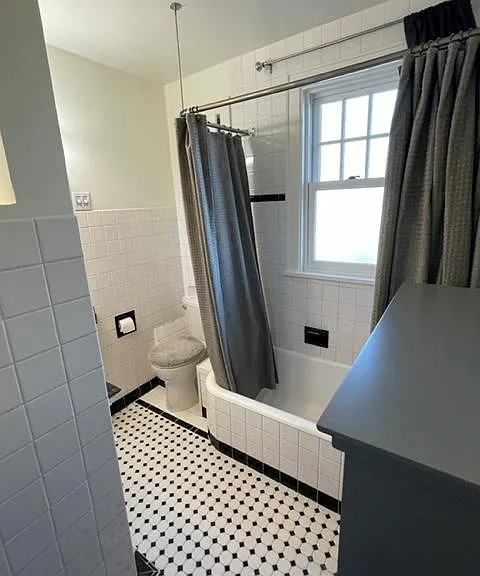 Full bath, additional view. Includes a lovely wood and glass, grey storage cabinet (top visible in foreground).