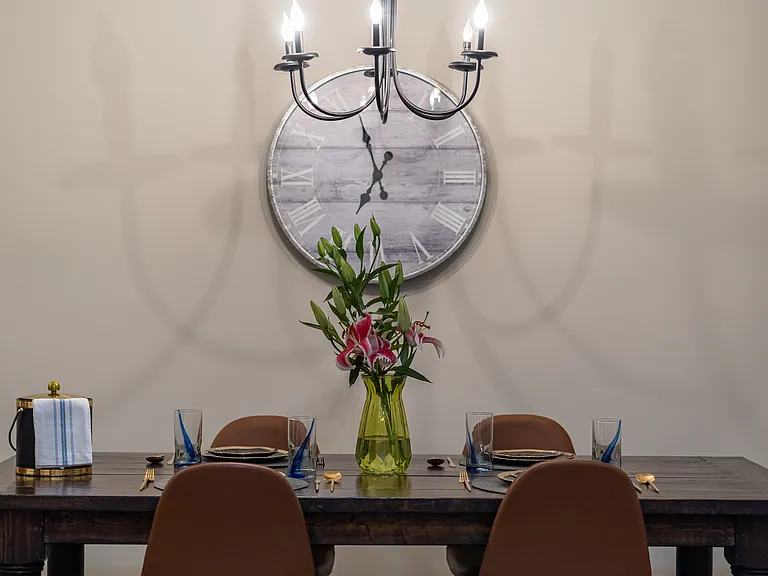Raise a glass to vacation! The table is set with elegant gold flatware and a sleek ice bucket, ready for your group's first evening toast