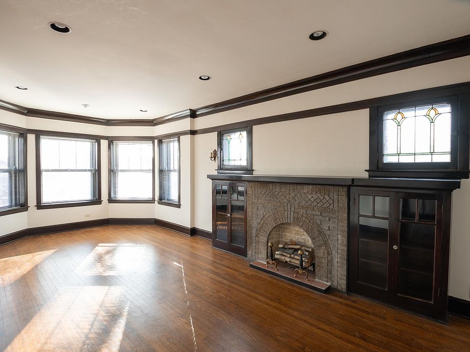 Living room with bay Art Glass windows, fireplace and bookcases.