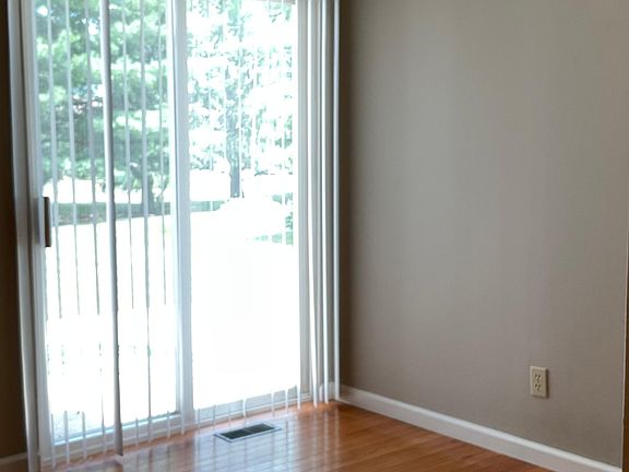 Dining area with hardwood flooring and access to concrete patio.