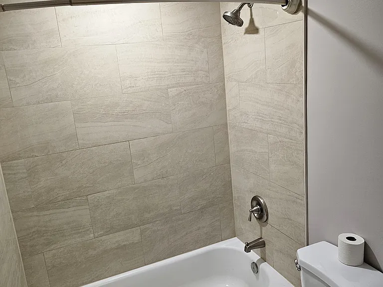 Fully remodeled upstairs bathroom with cream marble tile