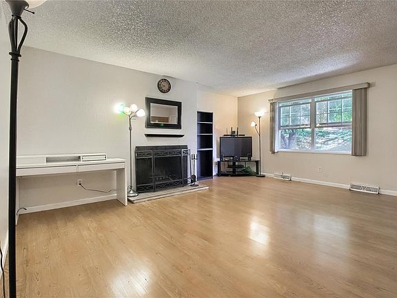 Spacious living room with gas burning fireplace and laminate floors.