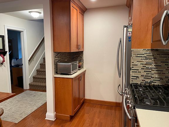 View of rest of kitchen and main hallway - open doorway is to den/home office.