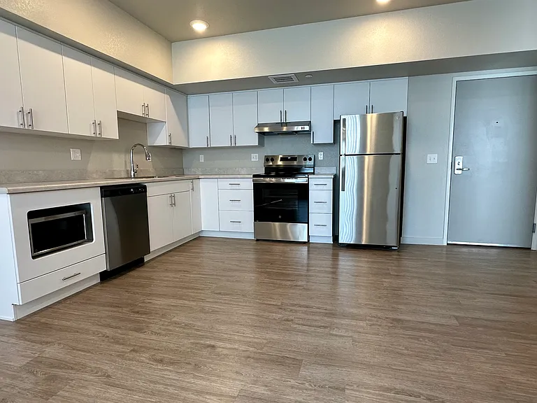 Kitchen with abundant cabinet space and full set of appliances. Opens to the living room.