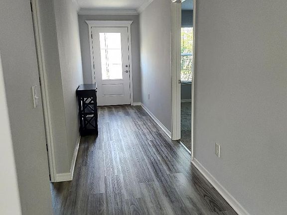 Entryway with bedroom and bathroom on left and bedroom on right