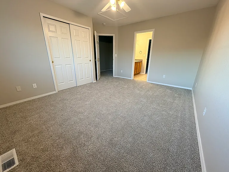 View from corner near window of secondary bedroom with double closets, natural light, and direct access to the Jack-and-Jill bathroom. Flexible layout works well as a bedroom, guest room, home office, creative space, or personal retreat.