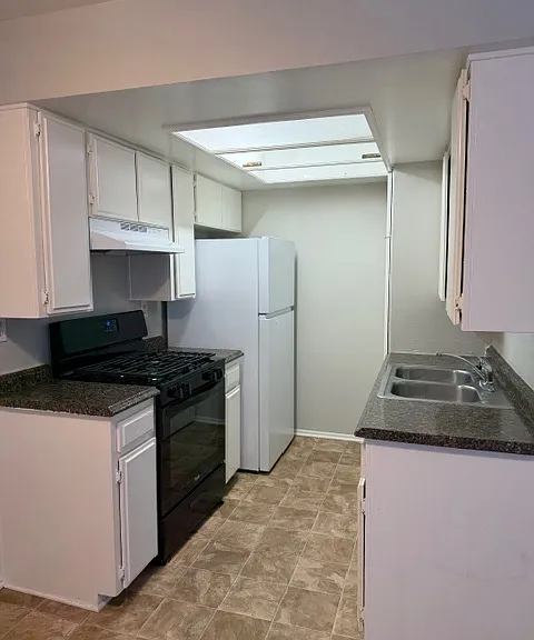 Galley kitchen with new stove and new refrigerator