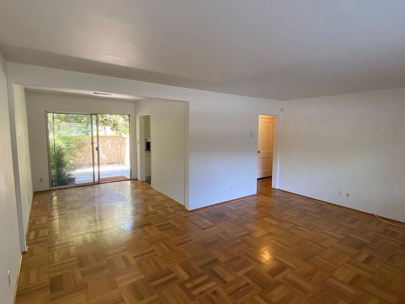 Panoramic view of living and dining room, with hallway to bedroom and bathroom on the right