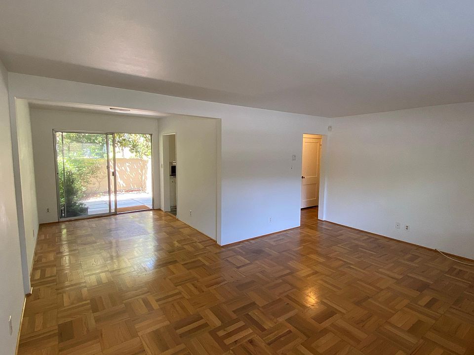 Panoramic view of living and dining room, with hallway to bedroom and bathroom on the right